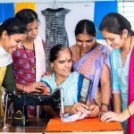 roup of woman at tailoring class discuissing with teacher about cloth and stitching during training