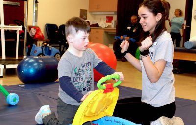 URI Nursing student Emily Nichols works with four-year-old Asher during a respite care program on campus.
