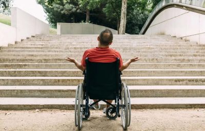 Man in wheelchair in front of the stairs