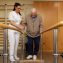 nurse helping elderly man walk