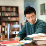 Student with Laptop studying in library