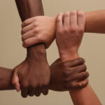 men joininf hands together on beige background