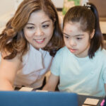 Mother Smiling Beside Her Daughter with Down Syndrome