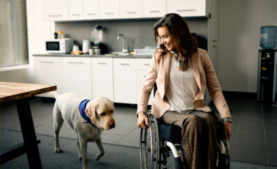 woman in wheelchair with her dog at home
