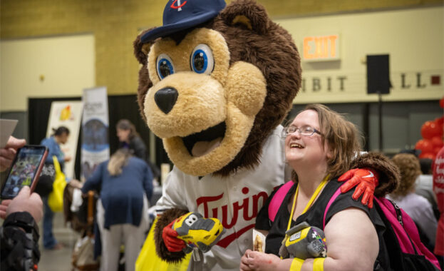 Woman with autism with mascot at Fraser Sensory Event at the MN Twins Game