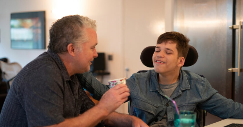 man in a wheelchair talking with carer