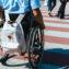 cropped image of man in wheelchair with bag riding on crosswalk