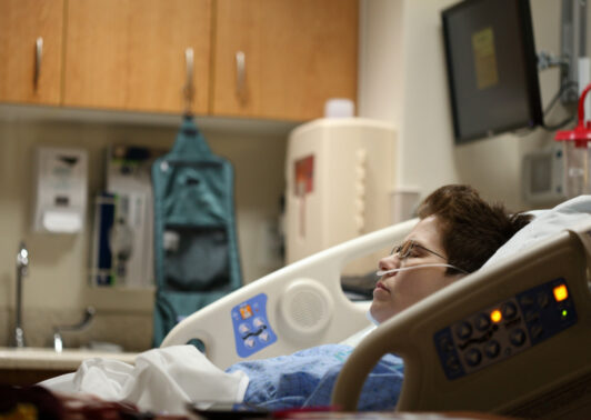 boy lying on beige recliner hospital bed