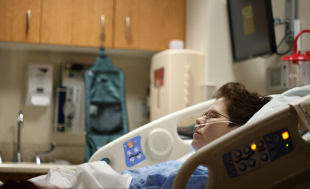 boy lying on beige recliner hospital bed