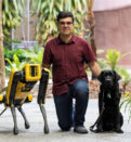 Santiago with robotic dog, Spot, and guide dog Trey
