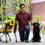 Santiago with robotic dog, Spot, and guide dog Trey
