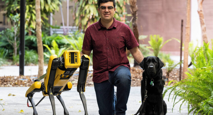Santiago with robotic dog, Spot, and guide dog Trey
