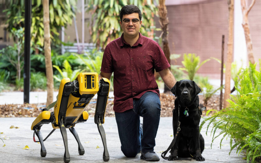 Santiago with robotic dog, Spot, and guide dog Trey