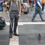 blind man with walking stick in the street
