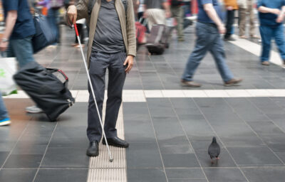 blind man with walking stick in the street