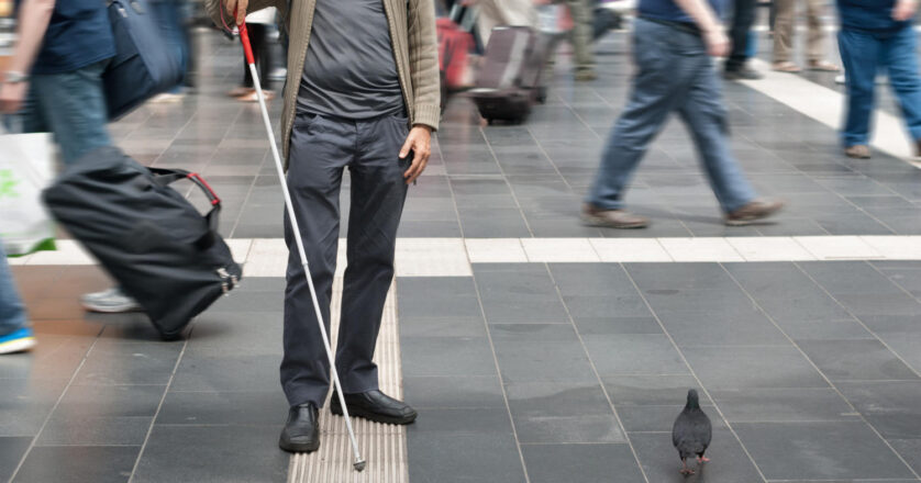 blind man with walking stick in the street
