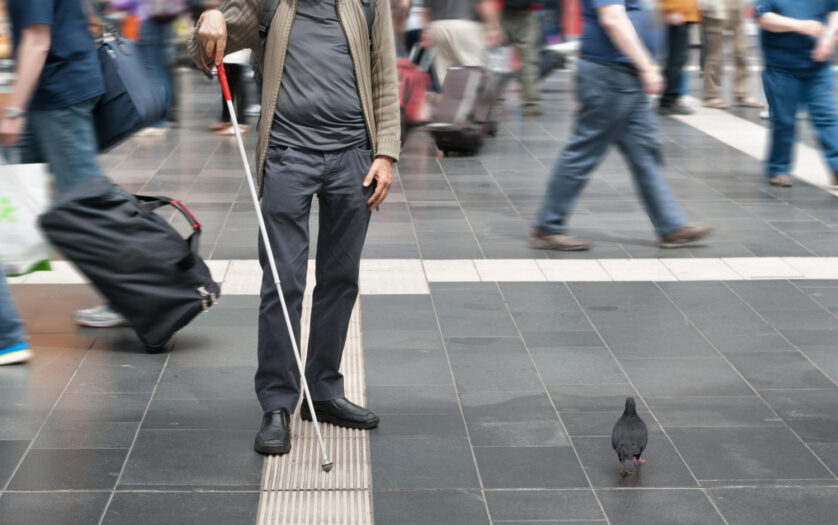 blind man with walking stick in the street