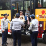 Girl in wheelchair geeting off the bus in the yard of Jakarta City Hall