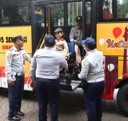 Girl in wheelchair geeting off the bus in the yard of Jakarta City Hall