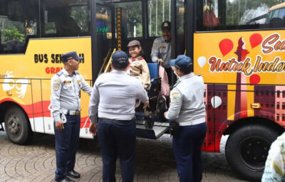 Girl in wheelchair geeting off the bus in the yard of Jakarta City Hall