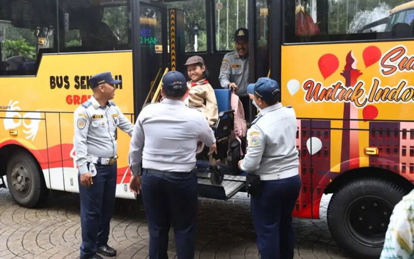 Girl in wheelchair geeting off the bus in the yard of Jakarta City Hall