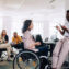 Women in wheelchair talking with her colleage in the office