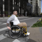 Man in wheelchair crossing the street