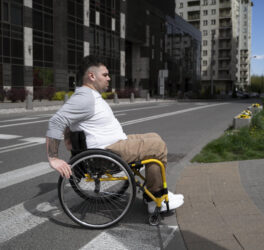 Man in wheelchair crossing the street