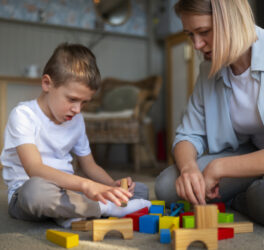 Mother playing with her autistic son using toys