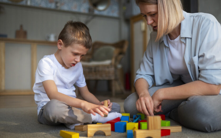Mother playing with her autistic son using toys