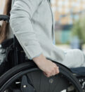 Close up of young woman in wheelchair entering building