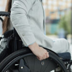 Close up of young woman in wheelchair entering building