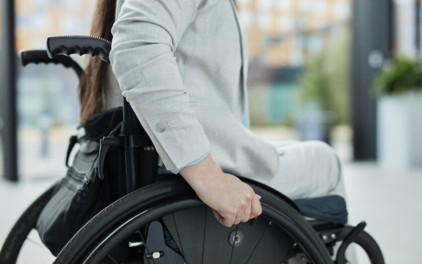 Close up of young woman in wheelchair entering building