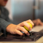 Close up of a kid hand on adaptive mouse using computer