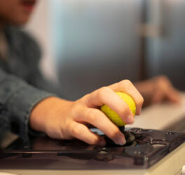 Close up of a kid hand on adaptive mouse using computer