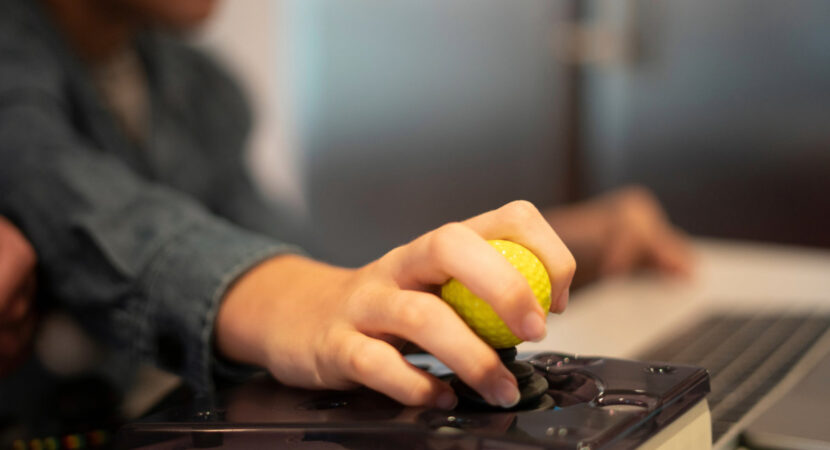 Close up of a kid hand on adaptive mouse using computer