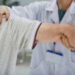 Senior man having shoulder and arm treatment in hospital