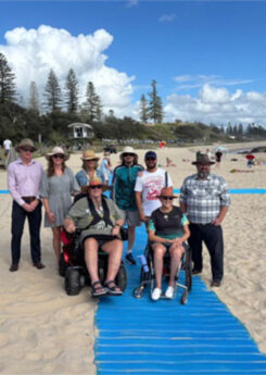 Group photo, including wheelchair users at the beach