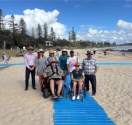 Group photo, including wheelchair users at the beach