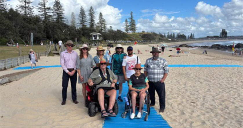 Group photo, including wheelchair users at the beach