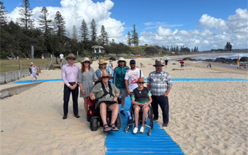 Group photo, including wheelchair users at the beach
