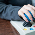 Close up of a woman hand on adaptive mouse using computer