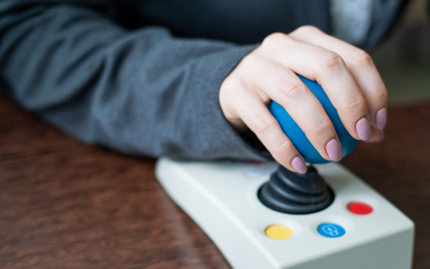 Close up of a woman hand on adaptive mouse using computer