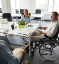 Man in wheelchair having meeting with colleagues in the office