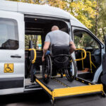 A man in a wheelchair on a lift of an accessible vehicle