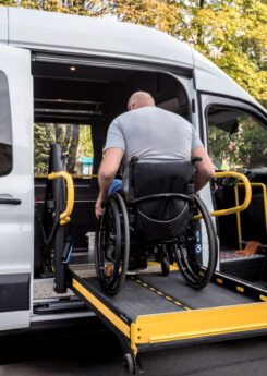 A man in a wheelchair on a lift of an accessible vehicle