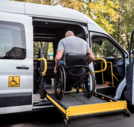 A man in a wheelchair on a lift of an accessible vehicle