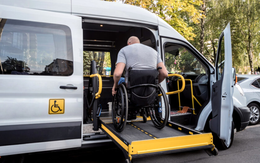 A man in a wheelchair on a lift of an accessible vehicle
