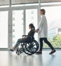doctor and walking with patient with disability in hospital