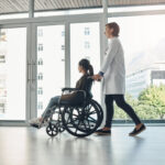 doctor and walking with patient with disability in hospital